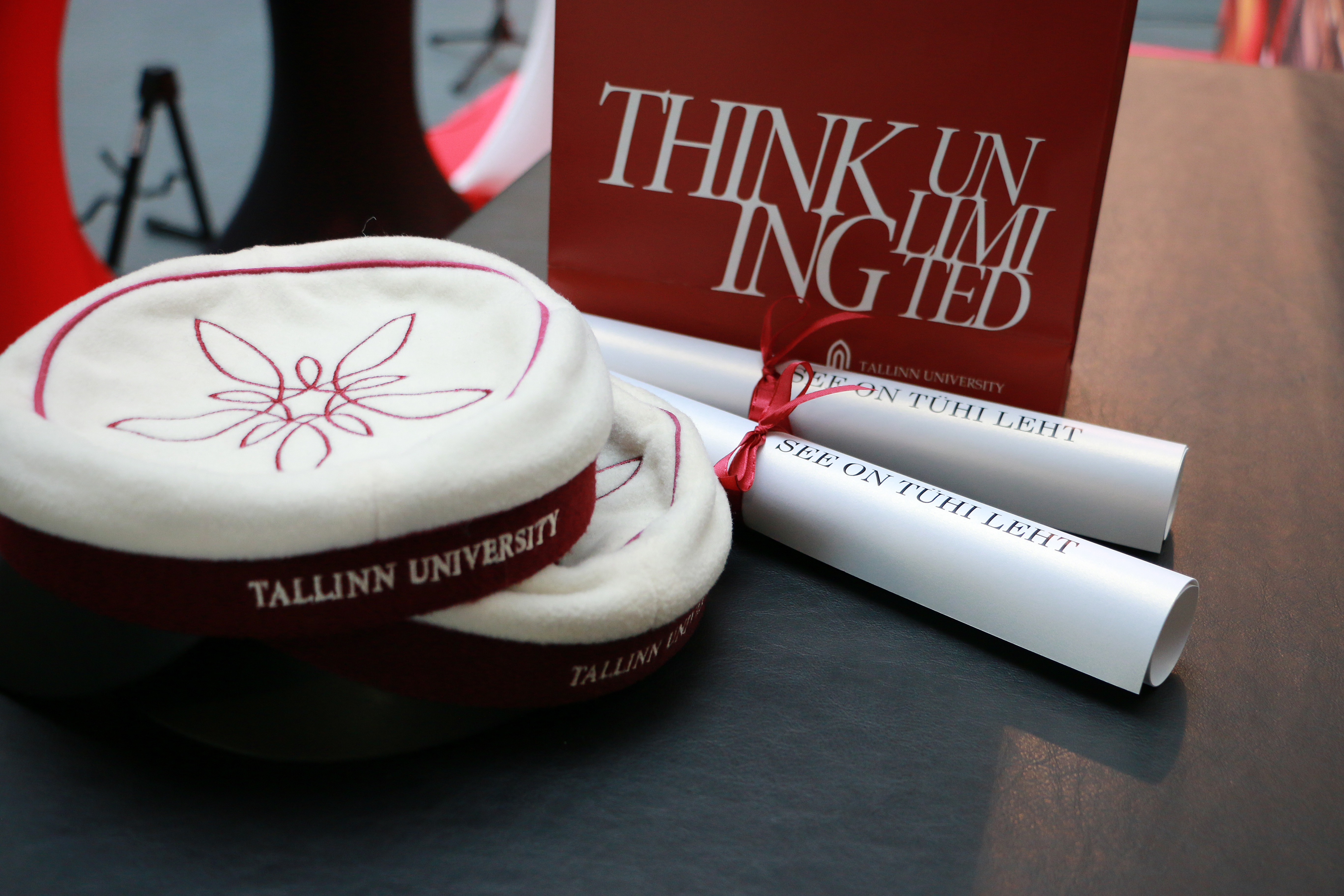 Tallinn University hats and a sign reading Thinking Unlimited